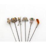 A collection of six silver hat pins, comprising four by Adie and Lovekin Limited, including: a teddy