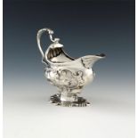 A George II cast silver cream boat, by Henry Hayens, London 1753, oval bellied form, leaf capped