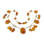 An amber mounted necklace, the metal links suspending five larger pendants and twelve smaller.