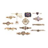 An early 20th century gold bar brooch set with a gem~set fly suspending a gem~set spider on a fine