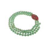 A three row jade bead necklace, with a diamond and enamel gold plaque clasp. 39cm.