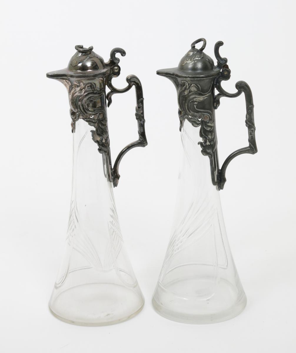 A pair of W.M.F pewter and glass decanters, with hinged covers, the cast with flowers, the glass