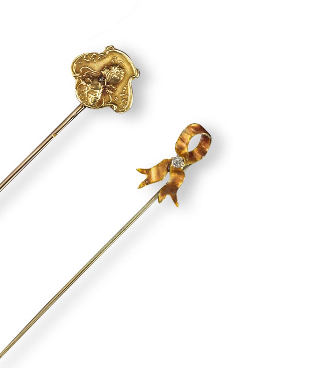 An Art Nouveau gold stickpin, depicting the profile of a young girl and set with a small diamond,
