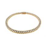 A diamond line bracelet, the seventy-one princess-cut diamonds are set in yellow gold. 18.2cm long.