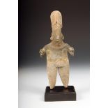 A Colima pottery standing figure, with remains of polychrome and with incised decoration, 18.5cm