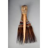 An Asmat cassowary bone dagger, with fibre, beads and feathers, 37cm long. Provenance Collected by