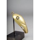 A Cameroon brass bird head pendant, 10.5cm high, with stand. (2)