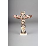 λ A Northwest Coast totem pole, walrus ivory with polychrome decoration, carved a bear holding a