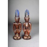 A pair of Yoruba Ibeji twin figures, male and female with five point coiffure with Reckitt's blue,