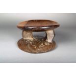 A Lega stool, D. R. Congo, carved wood of oval form with a dished top on two angled supports, the