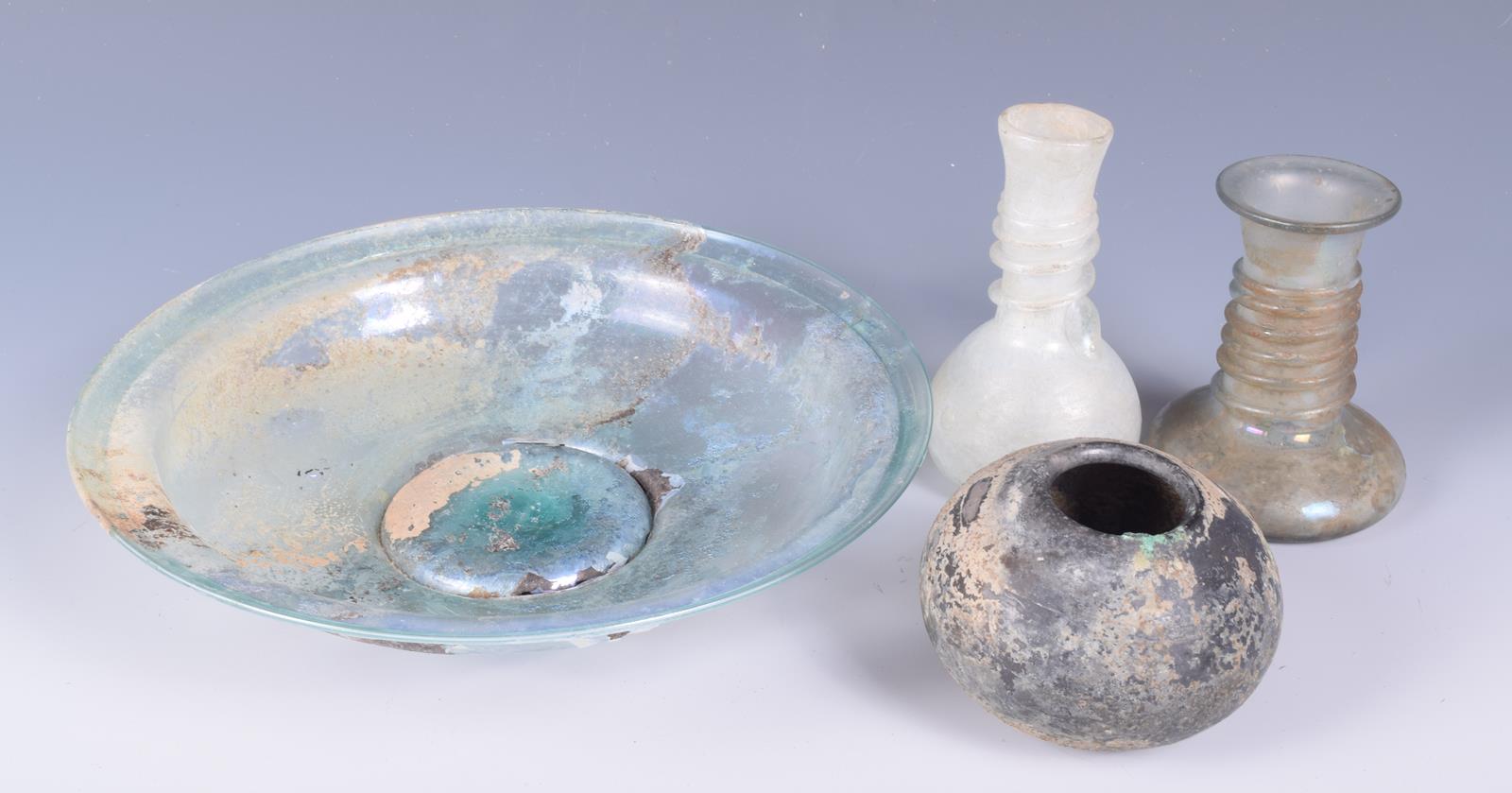 A Roman glass circular dish, on a spreading foot, 21.5cm diameter, two glass vessels with spiral - Image 2 of 4