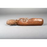 A Maori style patu, carved wood with a tiki to the handle and with shell inlay, 33.5cm long.