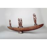 A Massim soul boat, Papua New Guinea, with incised decoration and four figures with their arms