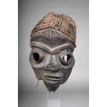 A Pende mask, D.R. Congo, with impressed dots to forehead and nose, with fibre coiffure, 34cm high.