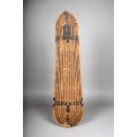 A Solomon Islands wicker shield, with stain decoration and woven handle, 86cm high. Provenance Dr