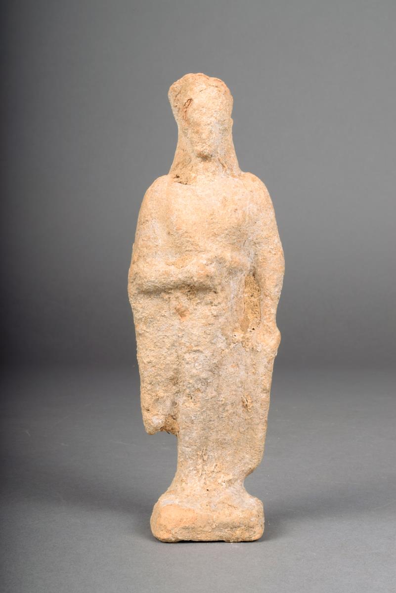 A Greek terracotta standing female, with headdress and robe, c. 5th century B.C., 15cm high.