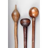 Three South African clubs; one Zulu with carved grooves to the spherical head, 50cm long, one with