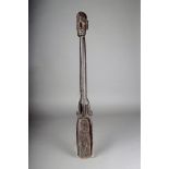 A Tami Island Sago scoop, with carved head terminal above carved bands, 84cm long. Provenance Ex