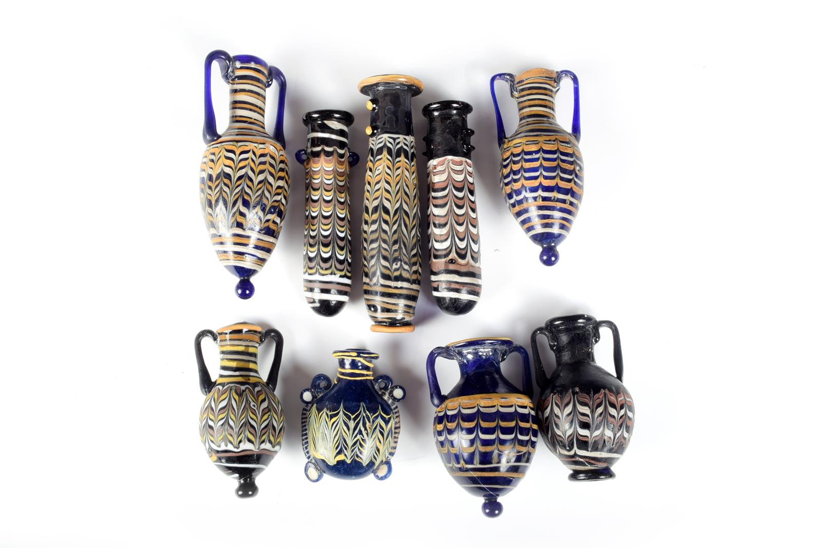 Nine core formed type glass vessels; five amphora shape, 12.5cm the highest. (9)