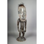 A Papua New Guinea standing ancestor figure, with clay and inset shells and figures, 88.5cm high.