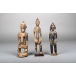 Three Senufo standing figures, Ivory Coast, one on a stand, 22.2cm, 20.8cm, 19.5cm high. (3)