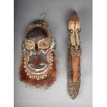 A Papua New Guinea mask, carved wood with clay, inset shells and fibre, 40cm high, and a Sepik