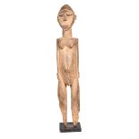 A Lobi standing male figure, Burkina Faso, the back of the head with a ridge and groove down the