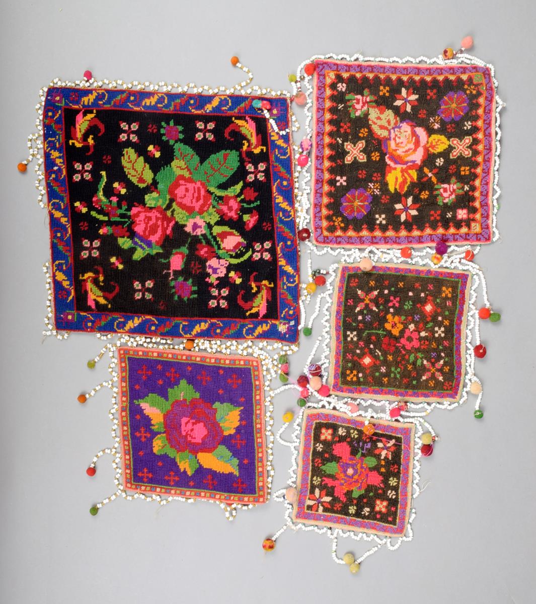 Five Batak needlework wedding pillows, Indonesia, square with floral designs and bead borders, the