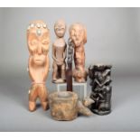 Three African carved wood figures, one with cowrie shells and beads, 33cm high, a Makonde carved