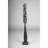 A Massim lime spatula, Papua New Guinea, with a stylised seated figure terminal, 35cm high, with a