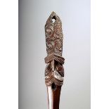 A Maori taiaha, quarter staff, carved with a Janus head and tongue with scroll and notch decoration,