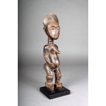 A Ghana standing maternal figure, 36cm high, on a stand. (2)