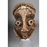 A Pende mask, D.R. Congo, with round eye sockets and mouth, with fibre and white pigment, 34cm