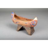 An Eastern Woodlands model canoe, carved wood with remains of polychrome decoration, on an