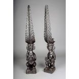 A matched pair of Nias seated ancestor figures, Indonesia, with elaborate pierced headdress, with