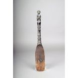 An Indonesian spatula, with a seated figure terminal, with knopped handle and flattened blade,