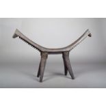 A Tikopia headrest, Melanesia, carved wood in three parts, with nodules to the outer edge of the