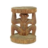 A Papua New Guinea carved wood table, with a male supporting figure inset shell eyes, 80cm high.