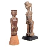 A Lobi standing female figure, Burkina Faso, with a horizontal cresting and her left arm raised to