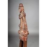 An Admiralty Islands canoe prow, Melanesia, carved with a crocodile devouring a human with large ear