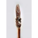 A Maori style taiaha, quarter staff, with carved decoration and applied shell eyes, 131cm long.