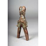 A Lobi catapult, Burkina Faso, carved male and female seated figures, with traces of green/blue