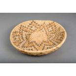 A California woven fibre coil bowl, with a raised centre and geometric pattern, 31.5cm diameter.