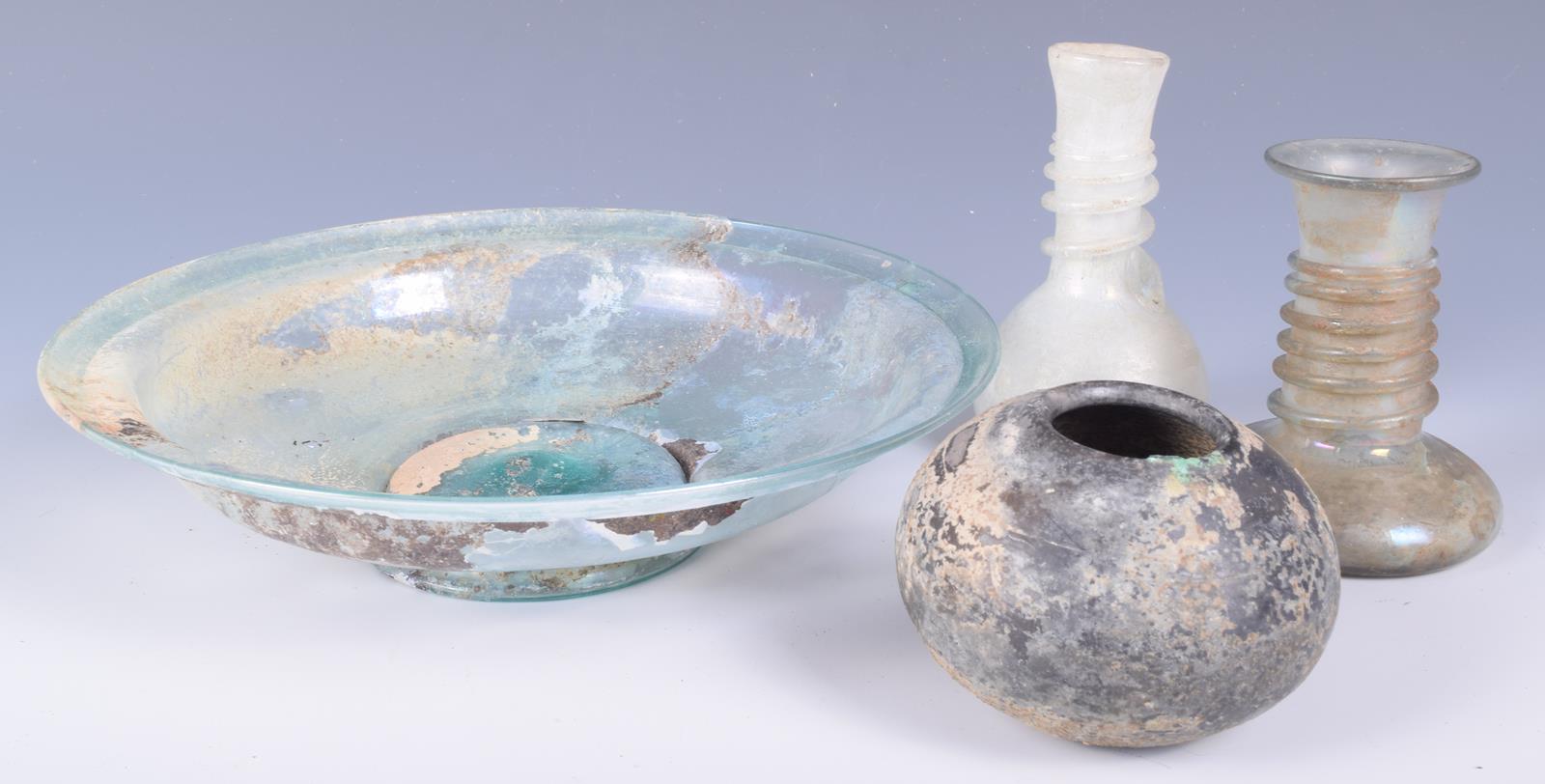 A Roman glass circular dish, on a spreading foot, 21.5cm diameter, two glass vessels with spiral - Image 3 of 4