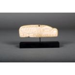 λ A Haida carved bone ornament, depicting a killer whale and a human mask, the top with pierced