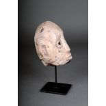 A Sumba carved stone head, Indonesia, with inlaid eyes, 14cm high, on a stand. (2)