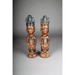 A pair of Yoruba Ibeji twin figures, male with central domed and pointed coiffure with Reckitt's