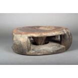 A Fang stool, Gabon, wood with a dished seat on four supports with a pierced base and a faceted