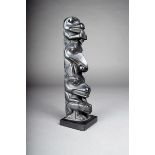 A Northwest Coast argillite totem, carved with a frog, bear, raven and beaver, on a square base,