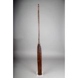 A Dayak paddle, Borneo, hardwood with a slender blade and carved decoration, 103cm long.